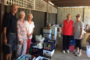 Volunteers standing amongst all the donations